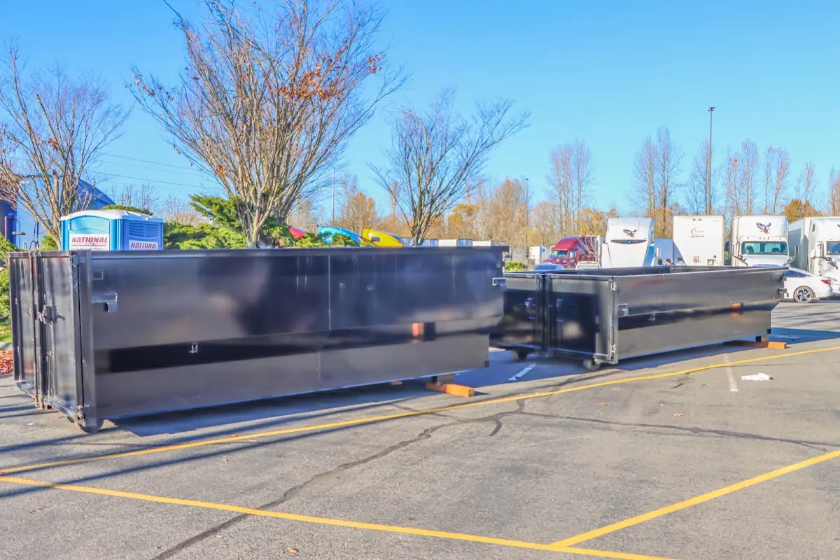 Professional dumpster rental service with roll-off container on residential driveway in Wasilla